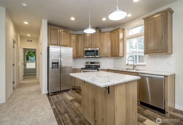a kitchen with stainless steel appliances granite countertop a sink stove and refrigerator