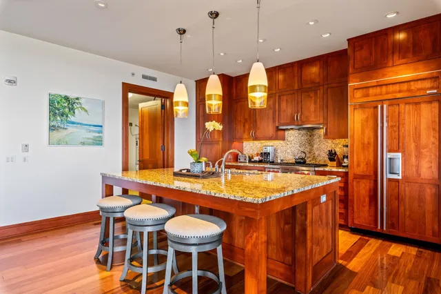 a kitchen with stainless steel appliances granite countertop a sink a stove and a wooden floors