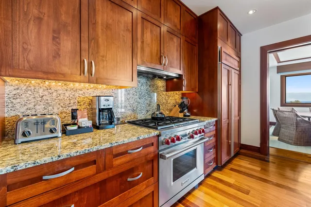 a kitchen with stainless steel appliances granite countertop a stove a sink and a microwave