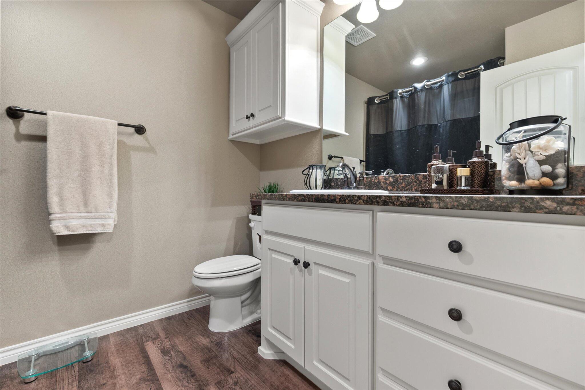 9606 Hope Avenue Lubbock, TX 79424 - Photo 16 of 35 a bathroom with a sink a toilet and mirror