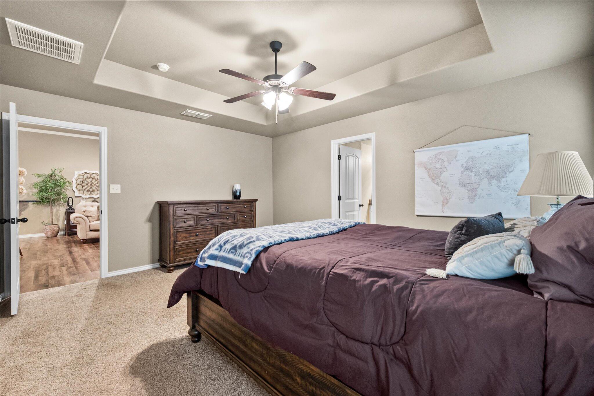9606 Hope Avenue Lubbock, TX 79424 - Photo 28 of 35 a bedroom with a bed ceiling fan and a wooden floor