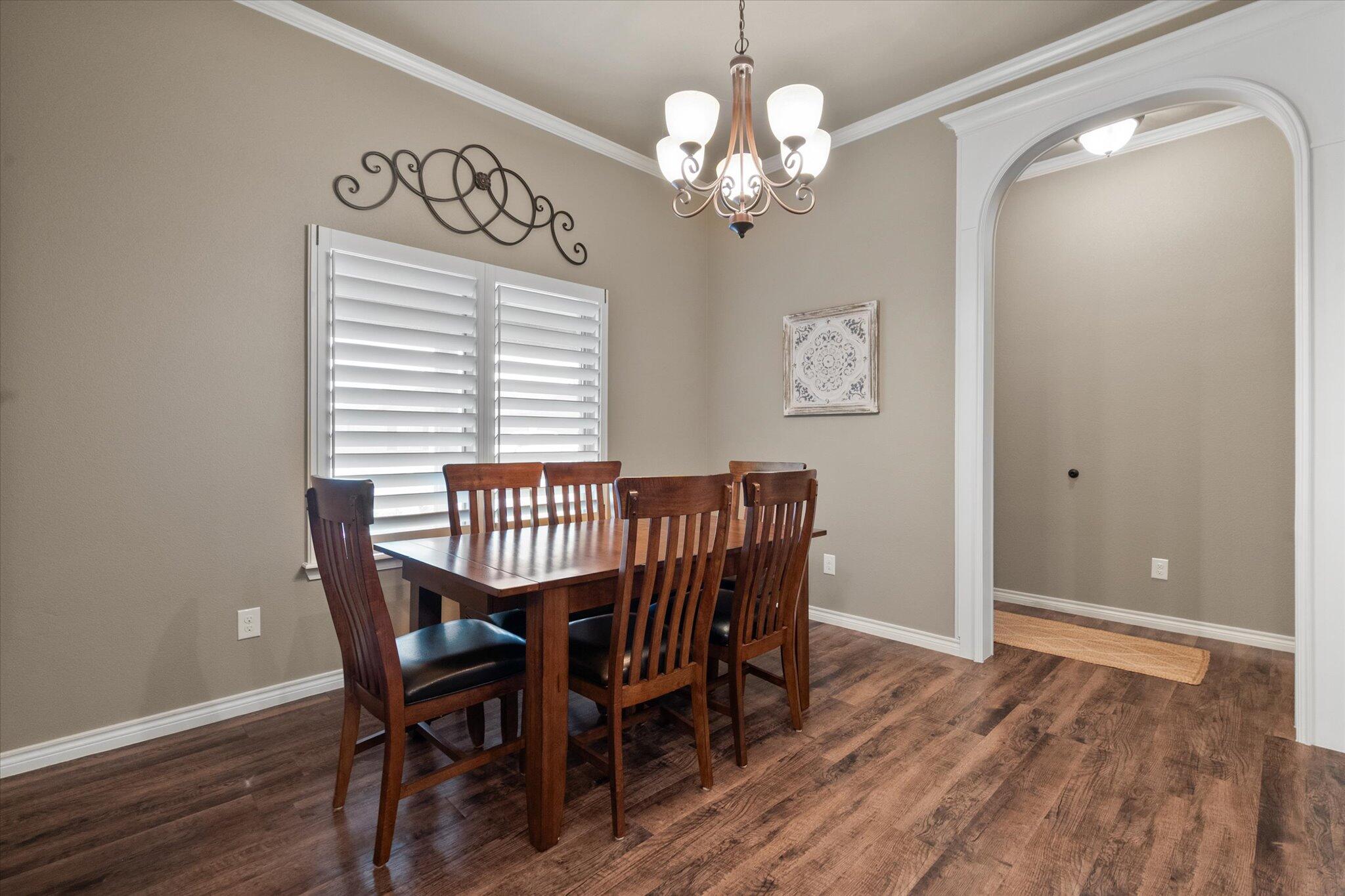 9606 Hope Avenue Lubbock, TX 79424 - Photo 7 of 35 a view of a dining room with furniture wooden floor and chandelier