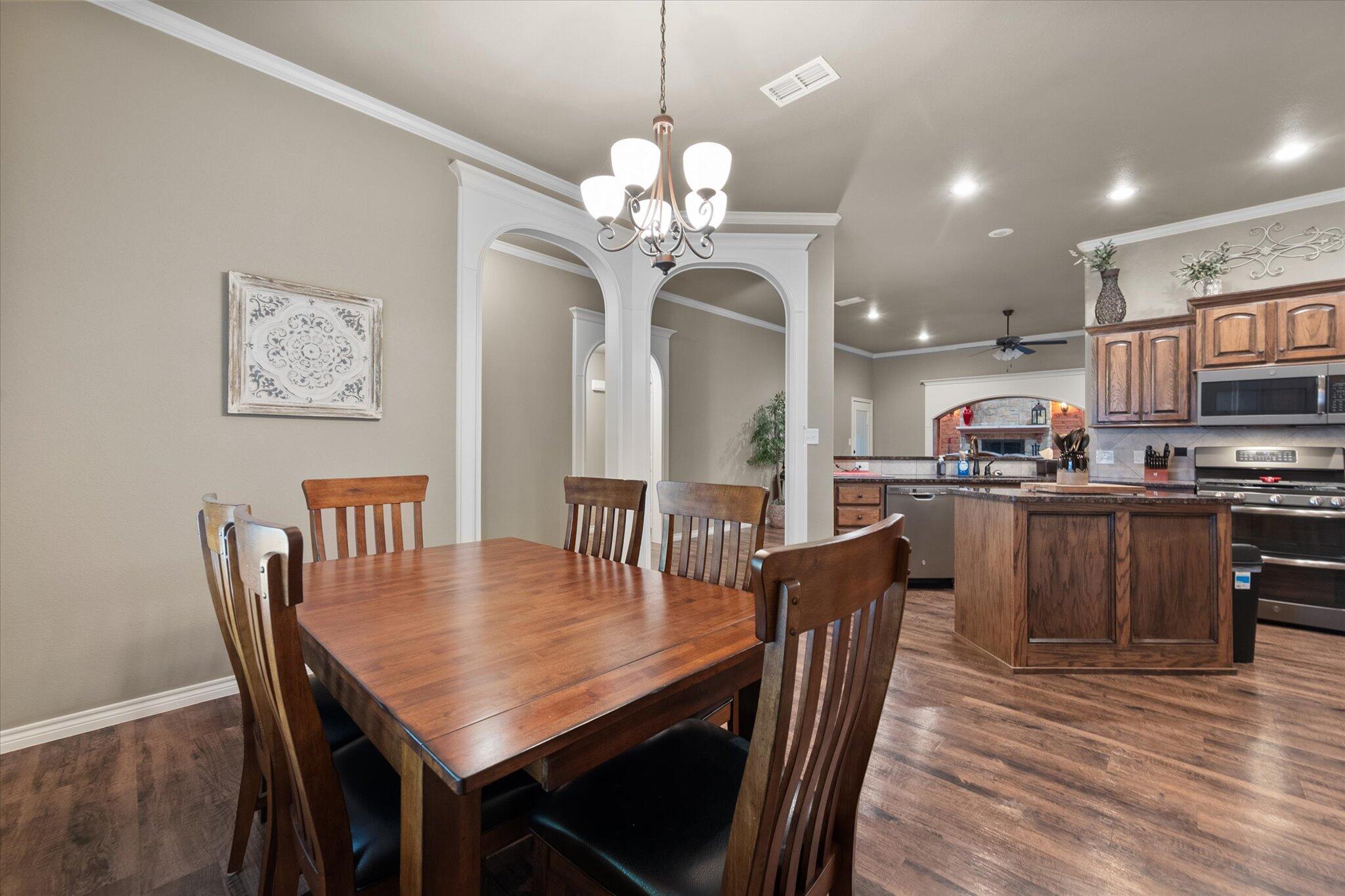 9606 Hope Avenue Lubbock, TX 79424 - Photo 8 of 35 a dining room filled chandelier and wooden floor