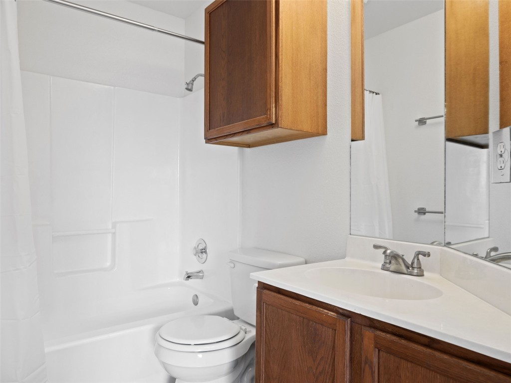 2908 Whisper Oaks Lane Georgetown, TX 78628 - Photo 14 of 32 a bathroom with a granite countertop sink a toilet and a mirror