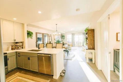 a large white kitchen with lots of counter top space and living room