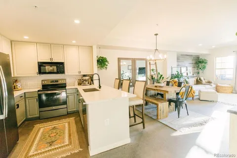 a kitchen with a table chairs refrigerator and microwave