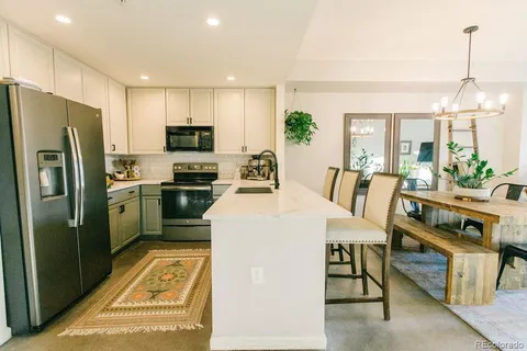 a kitchen with stainless steel appliances a refrigerator a stove a sink and a refrigerator