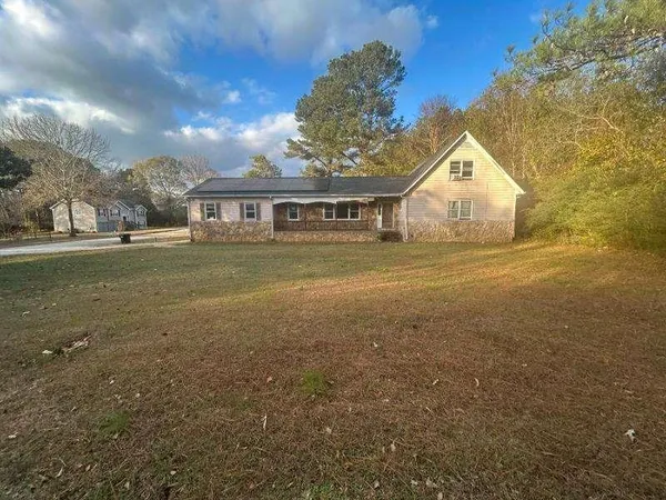 a view of big yard in front of house with trees