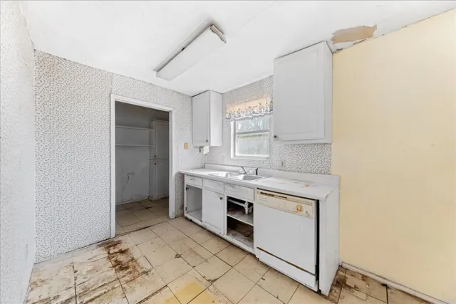 a kitchen with a stove sink and cabinets