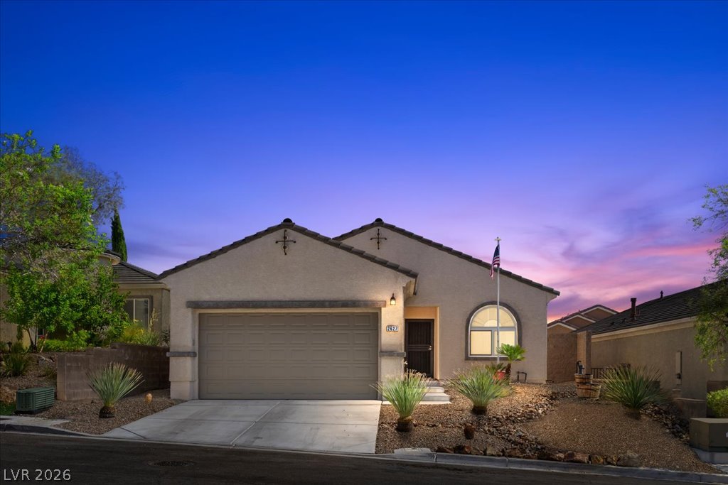 2627 Dirleton Place Henderson, NV 89044 - Photo 2 of 42 An inviting exterior with desert-friendly landscaping, an attached garage, and a charming arched window.