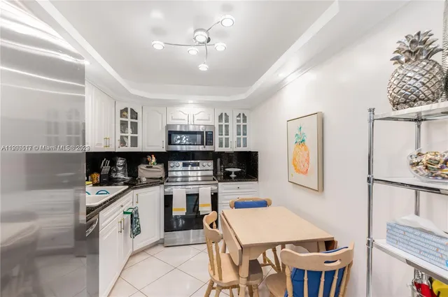 a kitchen that has a lot of cabinets a sink and appliances in it