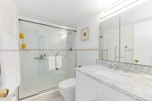 a bathroom with a granite countertop sink mirror vanity and toilet