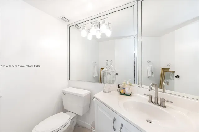 a bathroom with a sink mirror vanity and toilet