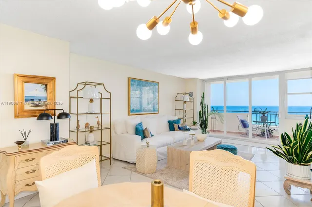 a living room with furniture a chandelier and a dining table
