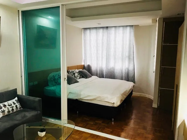 a bed sitting in a bedroom with a white comforter and pillows