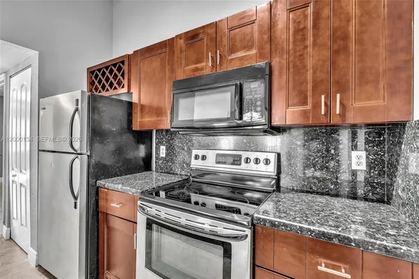 a kitchen with stainless steel appliances granite countertop a stove and a refrigerator