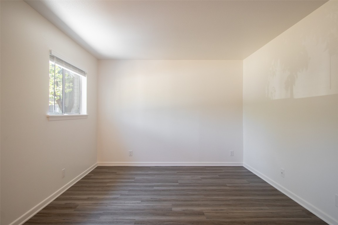 806 East 13th Street, Unit 105 Georgetown, TX 78626 - Photo 14 of 25 a view of an empty room with wooden floor and a window
