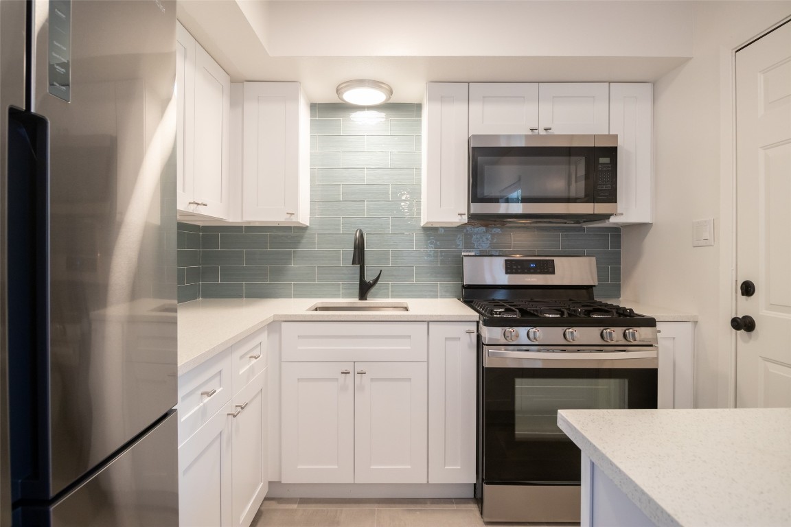 806 East 13th Street, Unit 105 Georgetown, TX 78626 - Photo 17 of 25 a kitchen with white cabinets and appliances