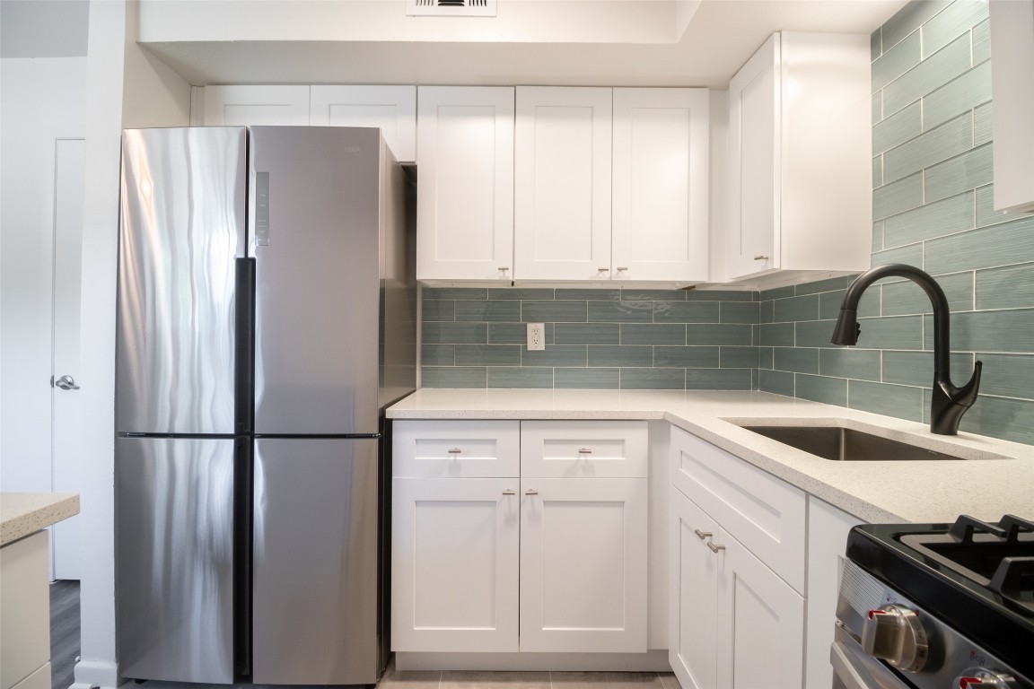 806 East 13th Street, Unit 105 Georgetown, TX 78626 - Photo 19 of 25 a kitchen with a refrigerator and cabinets