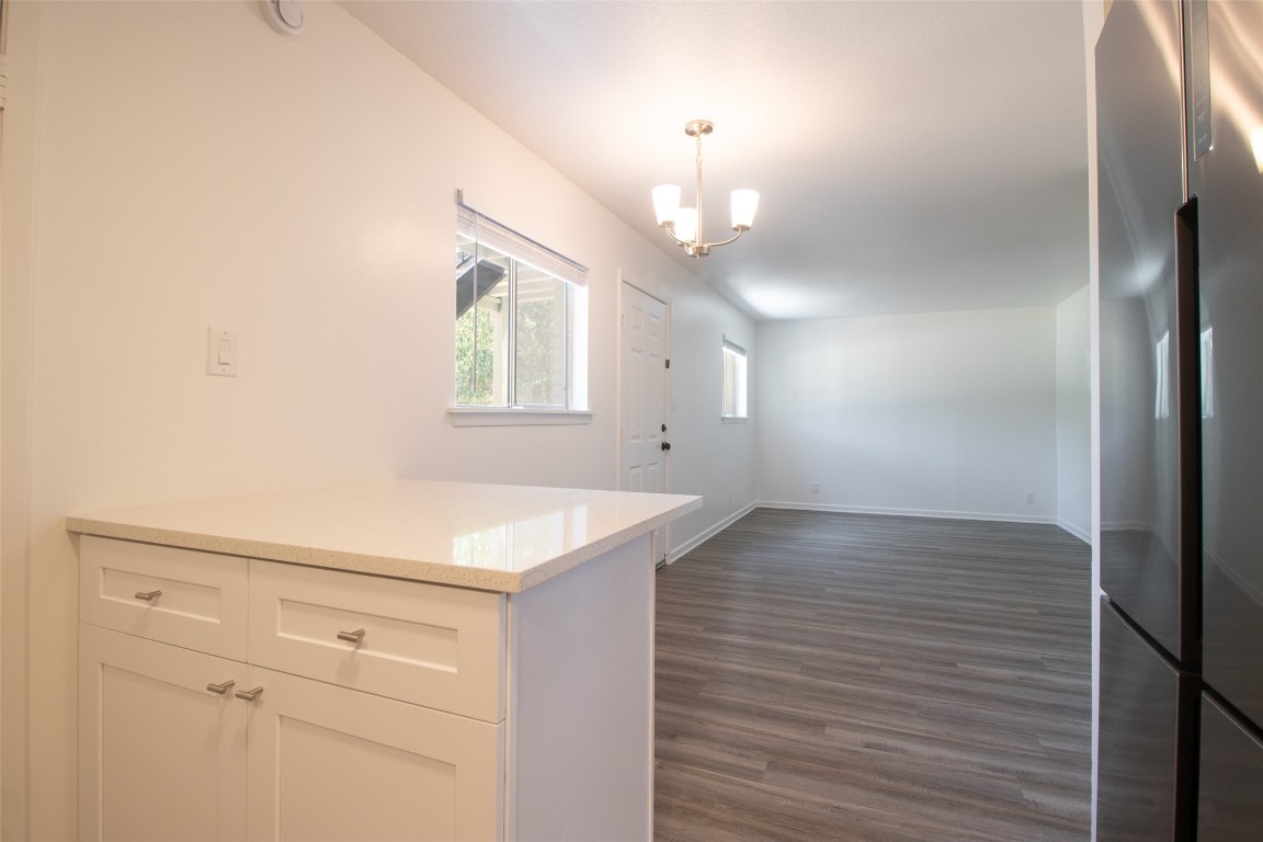 806 East 13th Street, Unit 105 Georgetown, TX 78626 - Photo 20 of 25 a view of a kitchen island wooden floor and staircase