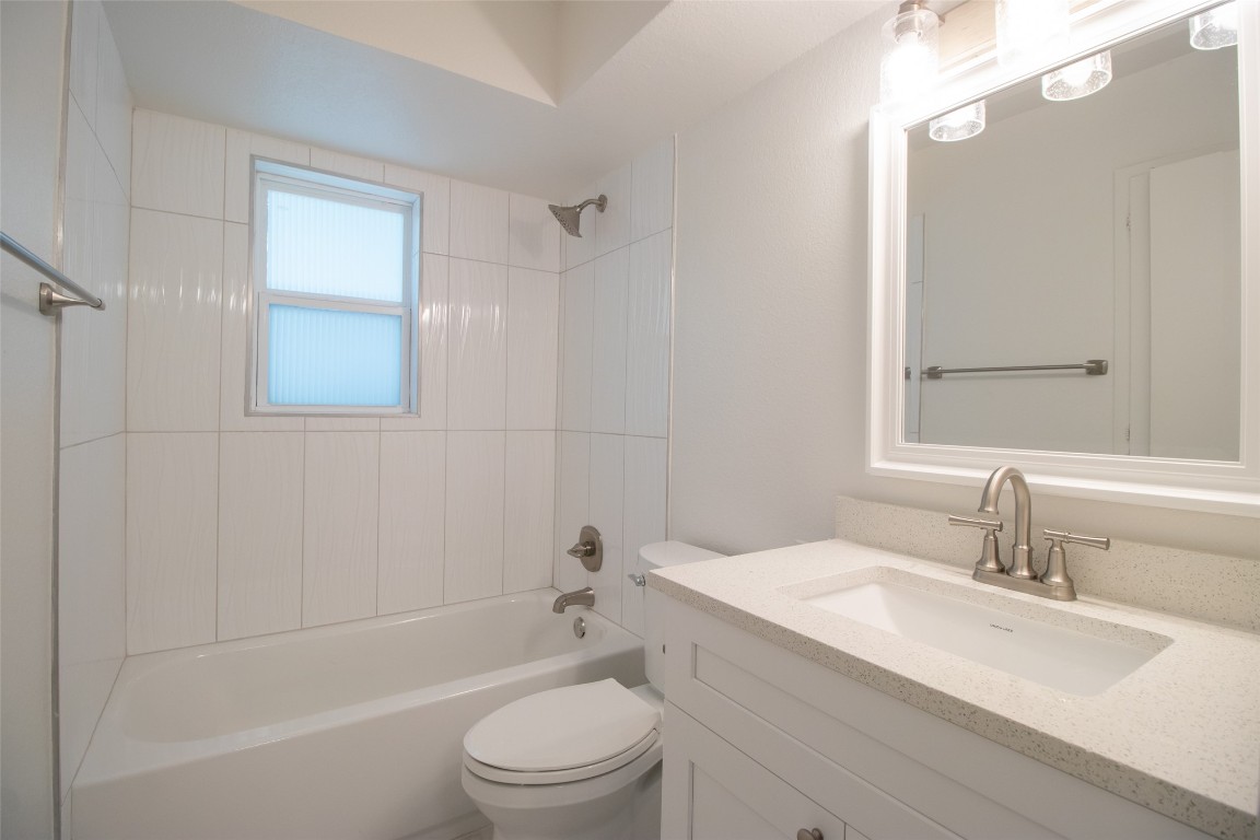 806 East 13th Street, Unit 105 Georgetown, TX 78626 - Photo 25 of 25 a bathroom with a granite countertop sink a toilet and shower