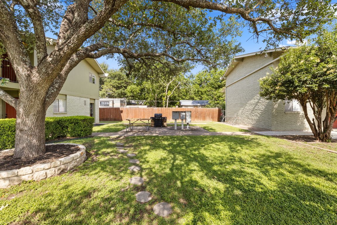 806 East 13th Street, Unit 105 Georgetown, TX 78626 - Photo 3 of 25 a view of a yard with plants and a large tree
