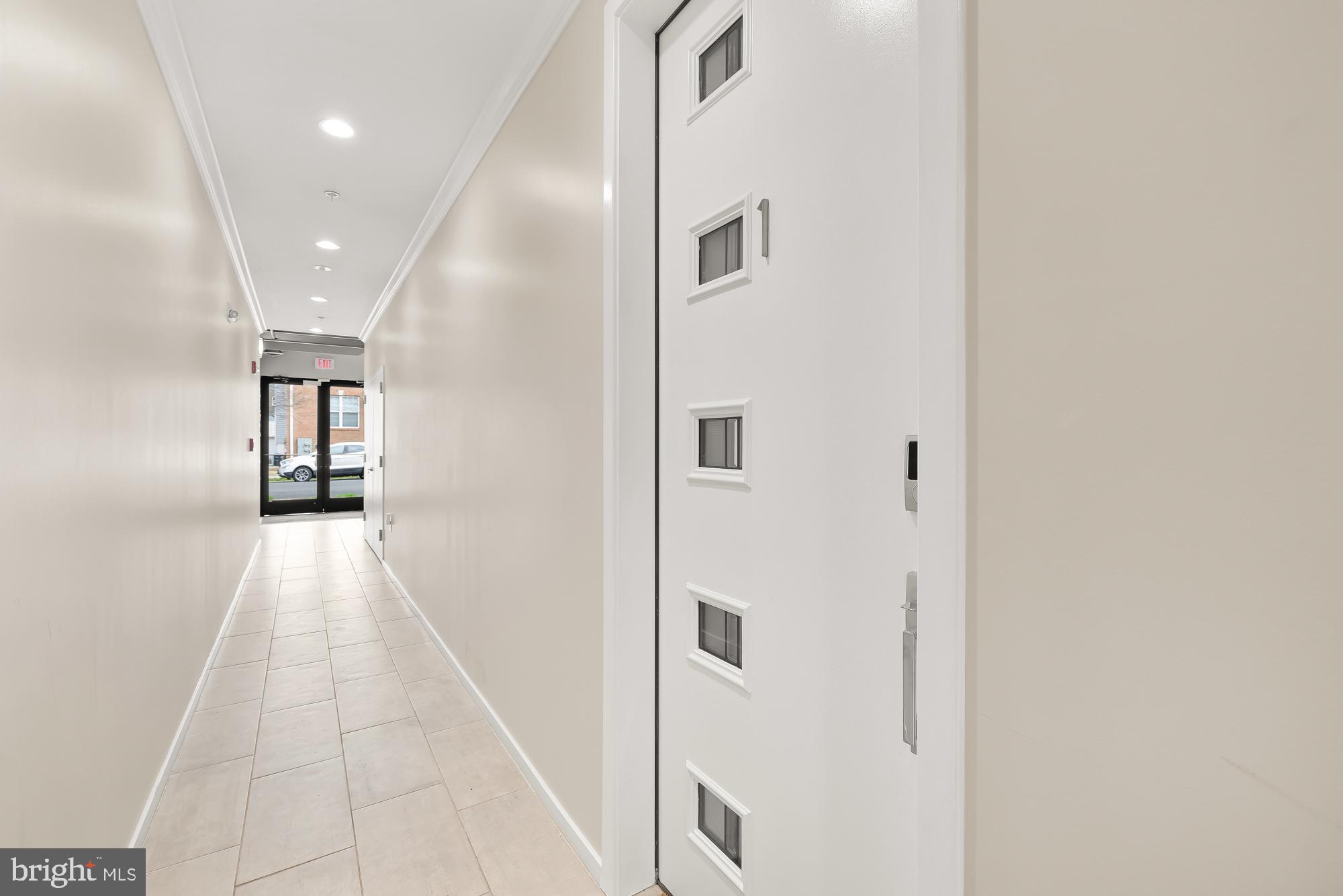 756 Park Road Northwest, Unit 1 Washington, DC 20010 - Photo 3 of 25 a view of a hallway with wooden floor and a bathroom