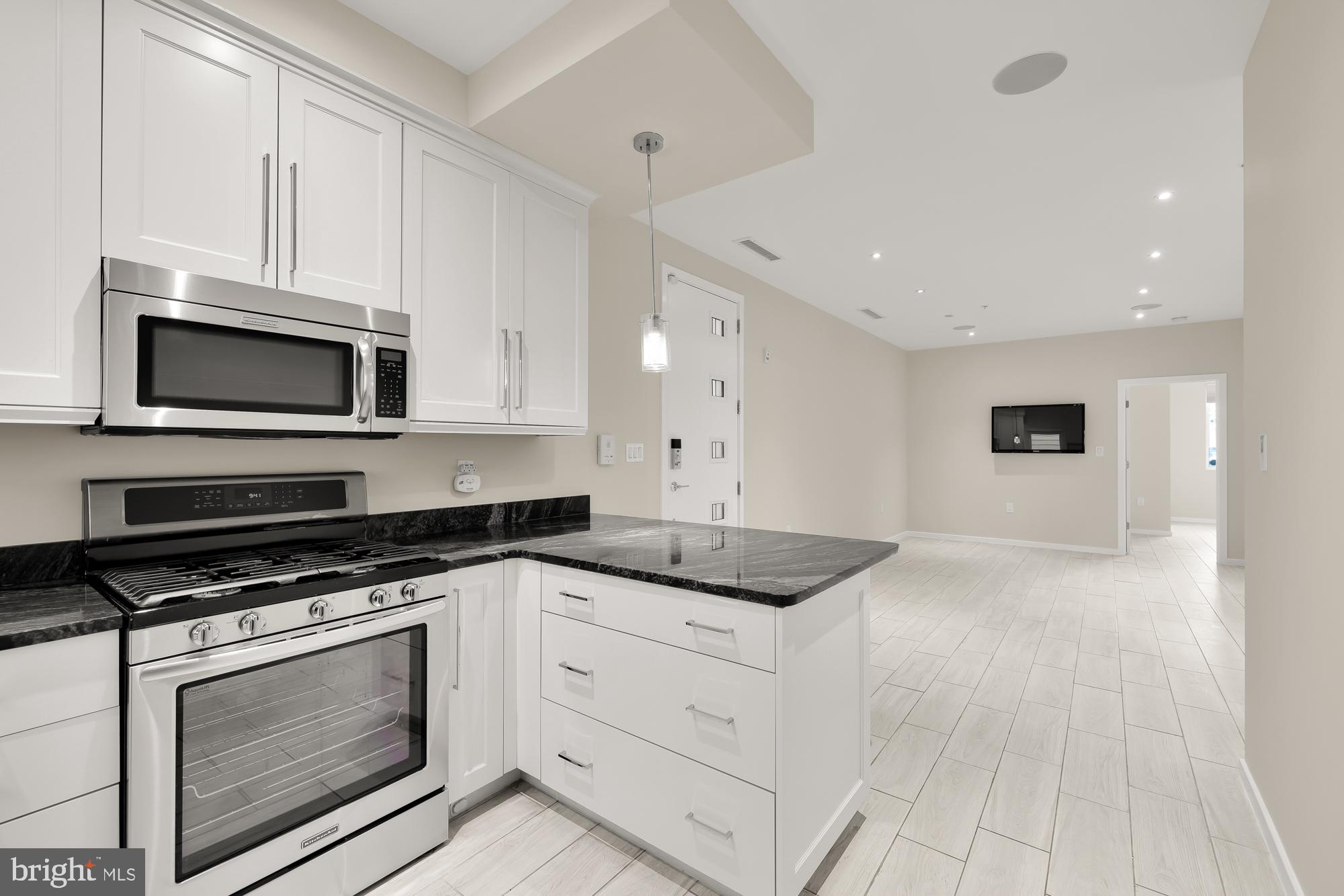 756 Park Road Northwest, Unit 1 Washington, DC 20010 - Photo 7 of 25 a kitchen with granite countertop white cabinets stainless steel appliances and a sink