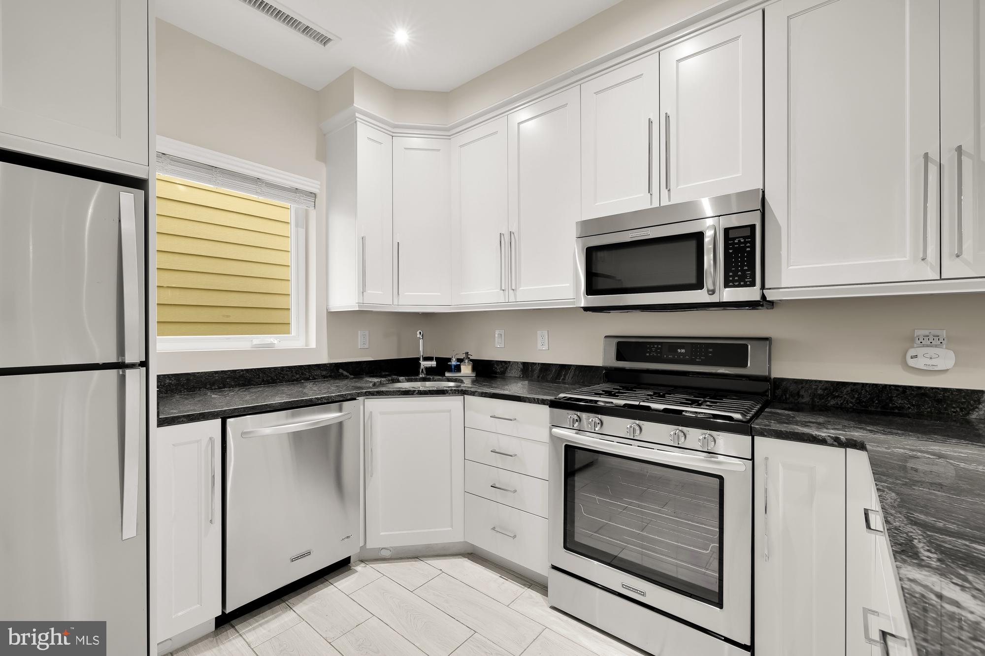756 Park Road Northwest, Unit 1 Washington, DC 20010 - Photo 8 of 25 a kitchen with white cabinets appliances and a sink