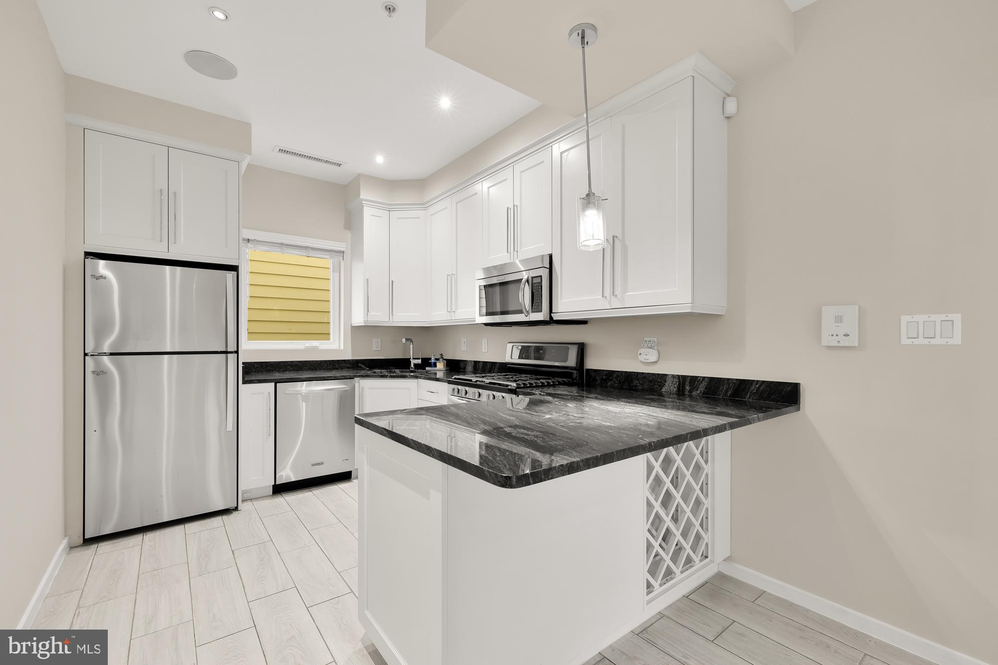 756 Park Road Northwest, Unit 1 Washington, DC 20010 - Photo 9 of 25 a kitchen with stainless steel appliances granite countertop a sink a stove a refrigerator and island with wooden floor