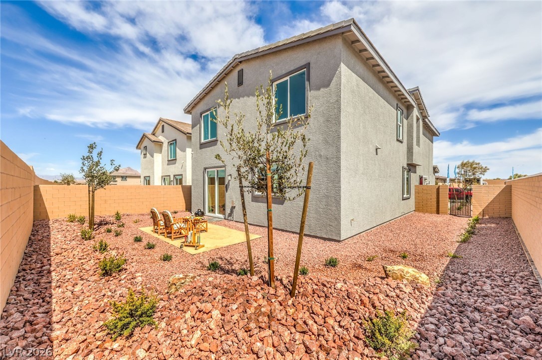1017 Copper Robin Street Henderson, NV 89011 - Photo 41 of 43 Photo is representational only; actual home finishes may vary. Rear view of property featuring a gate, a fenced backyard, a patio area, and stucco siding