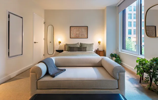 a bedroom with furniture and a large window