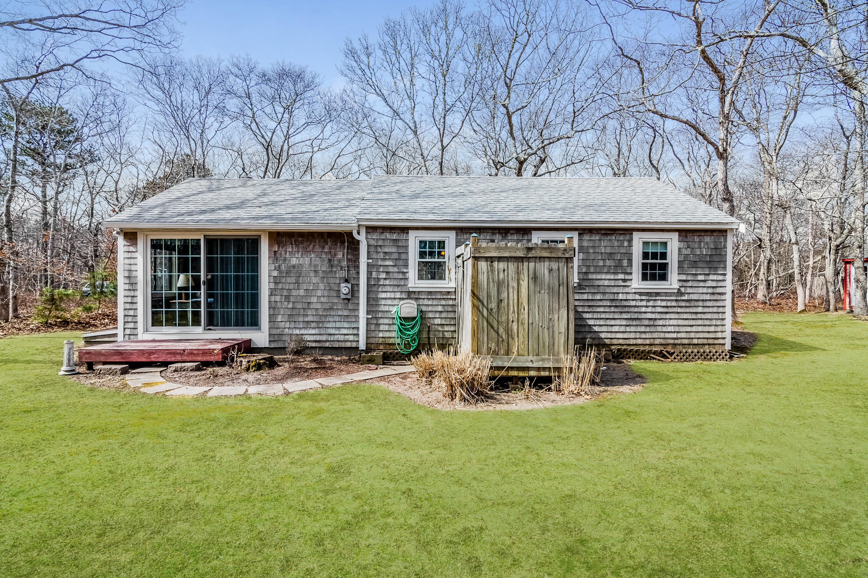 20 Hidden Lane Eastham, MA 02642 - Photo 20 of 21 a front view of a house with a garden and chairs