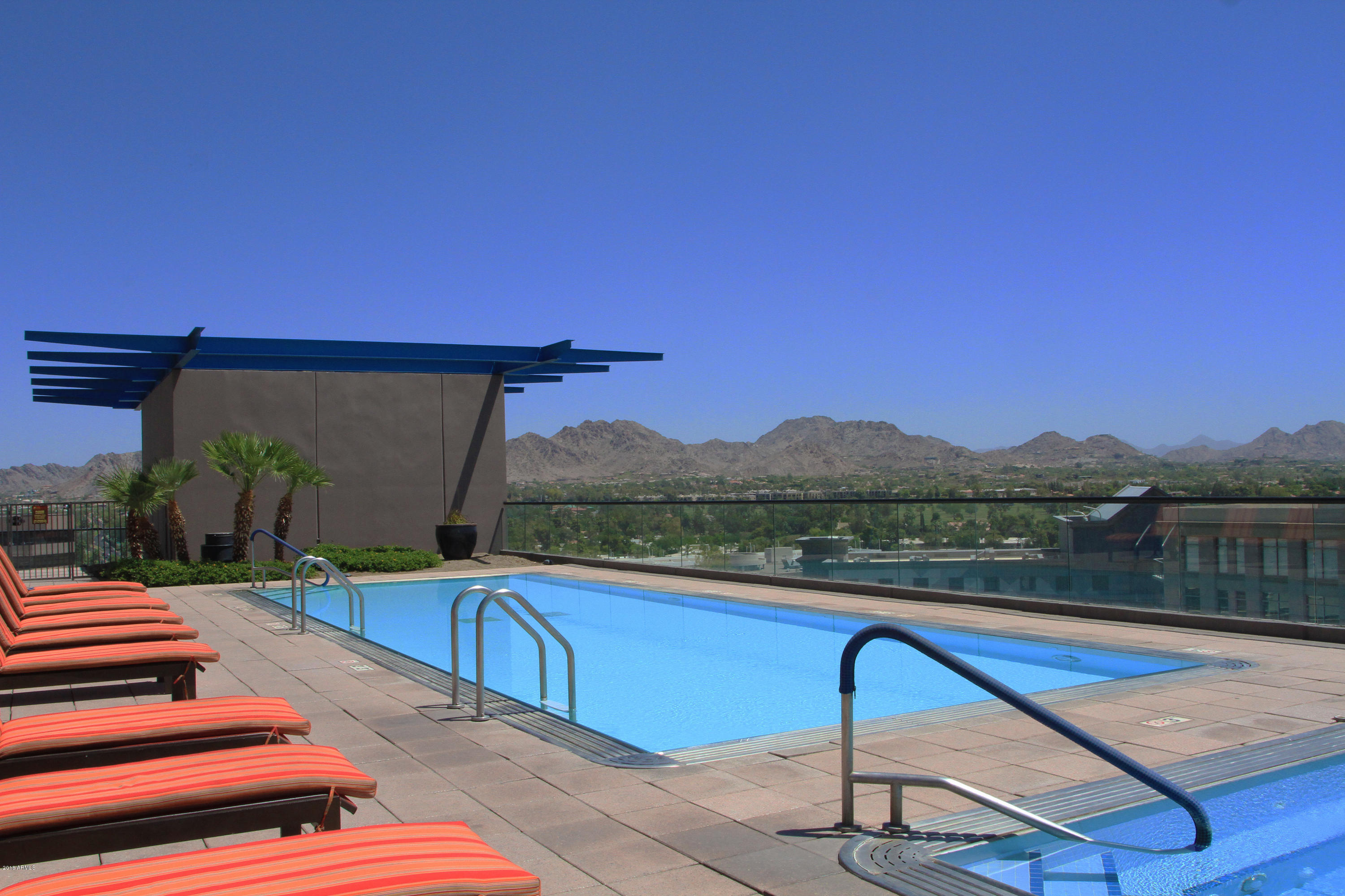 4808 North 24th Street, Unit 605 Phoenix, AZ 85016 - Photo 24 of 27 a view of swimming pool with a table and chairs under an umbrella