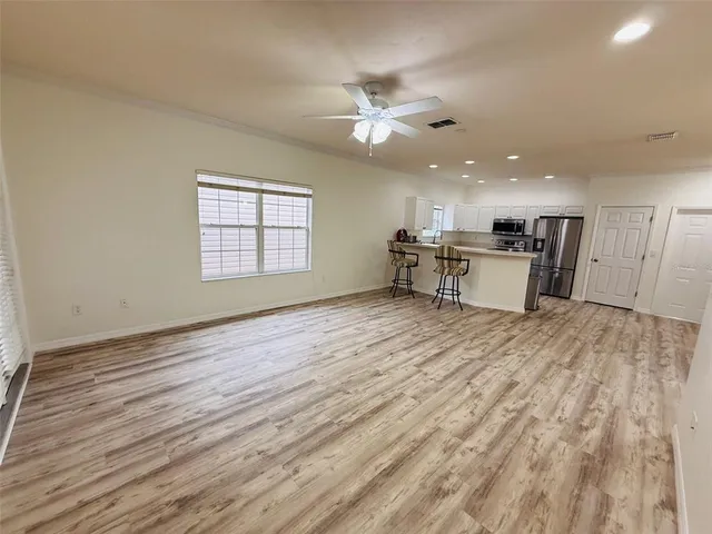 a view of an empty room with window and wooden floor