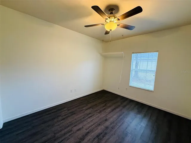 an empty room with a window and a ceiling fan