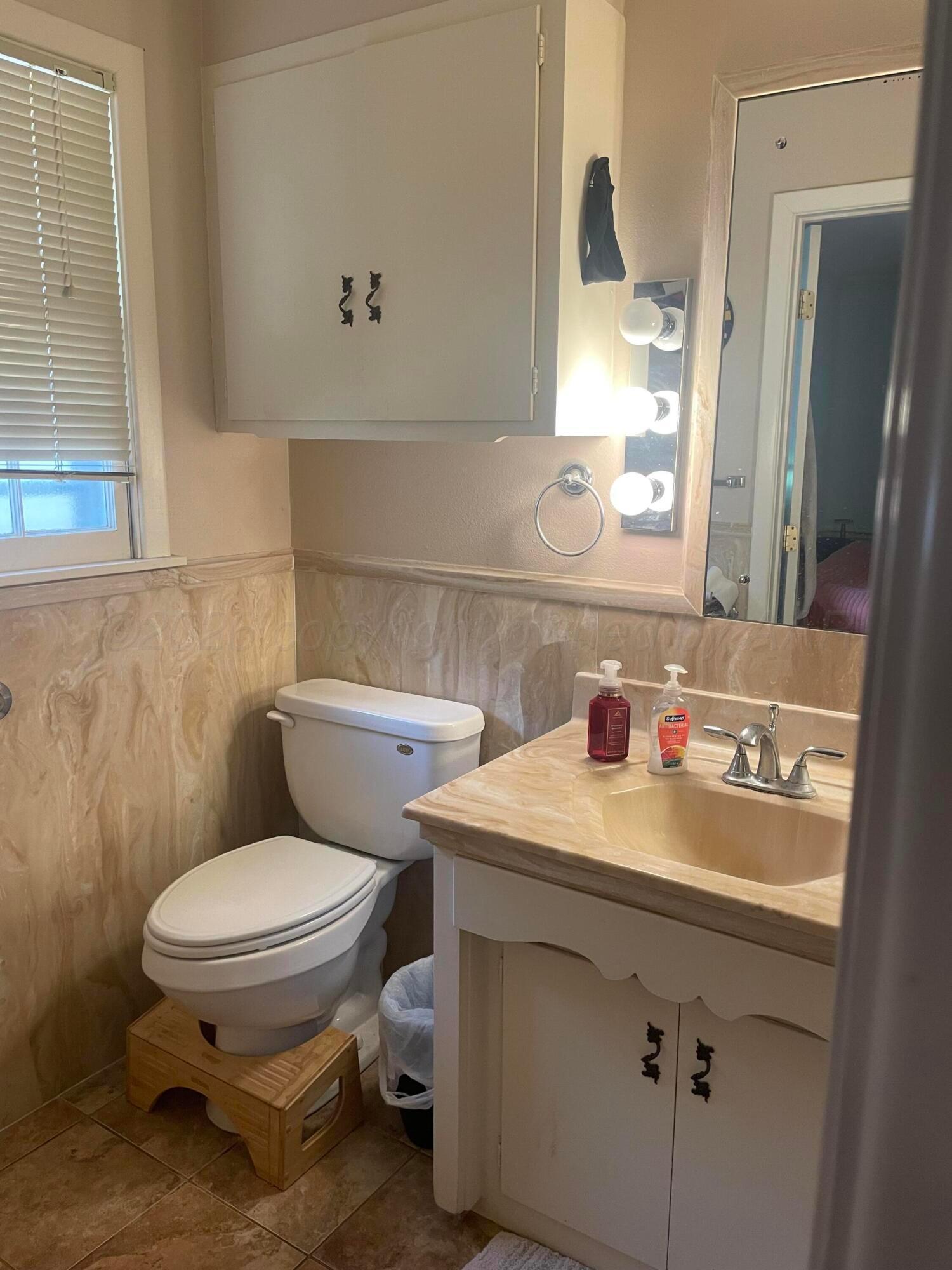 6200 Hanson Road Amarillo, TX 79106 - Photo 11 of 22 a bathroom with a toilet sink and mirror