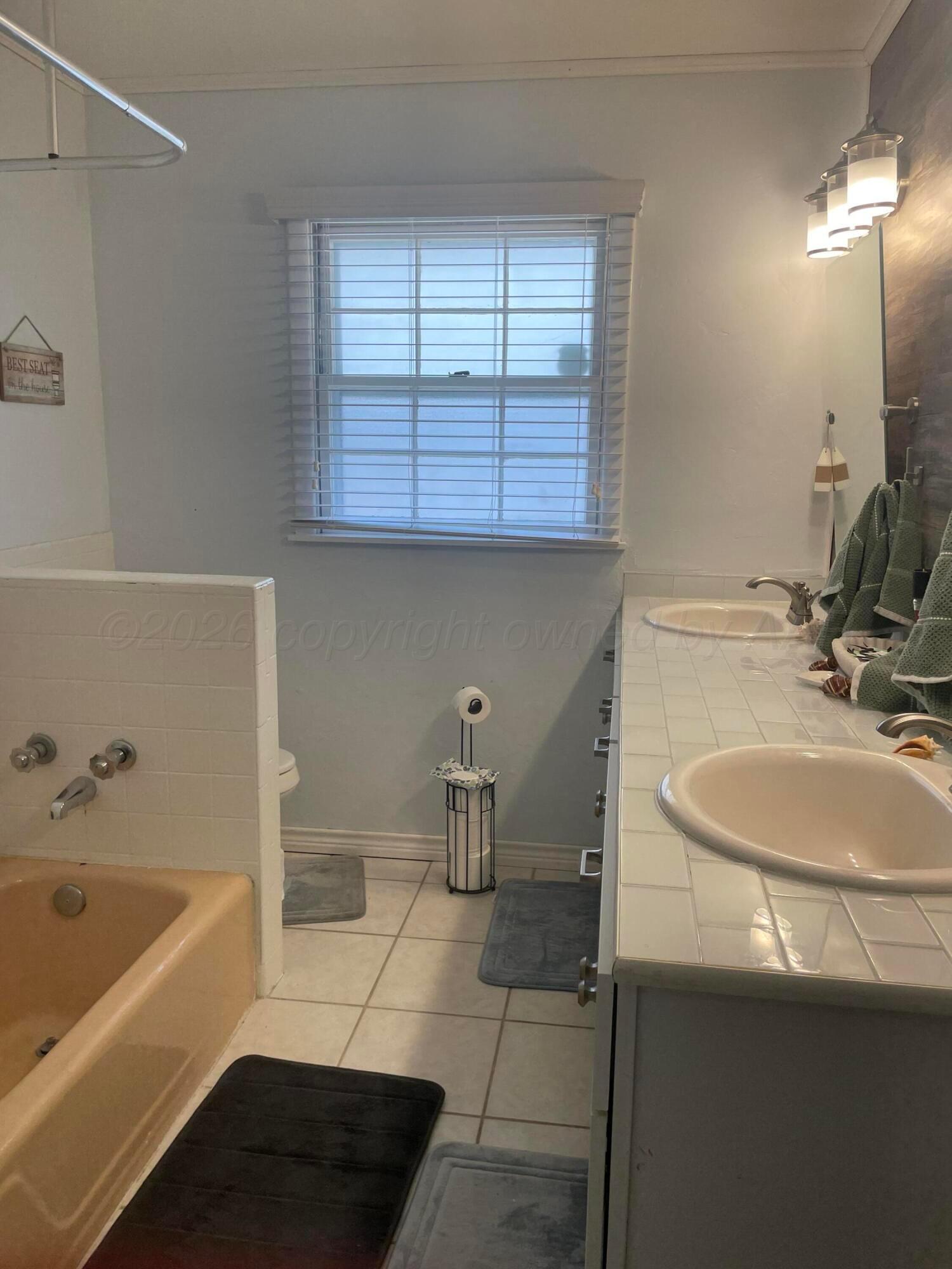 6200 Hanson Road Amarillo, TX 79106 - Photo 14 of 22 a bathroom with a sink and a bathtub