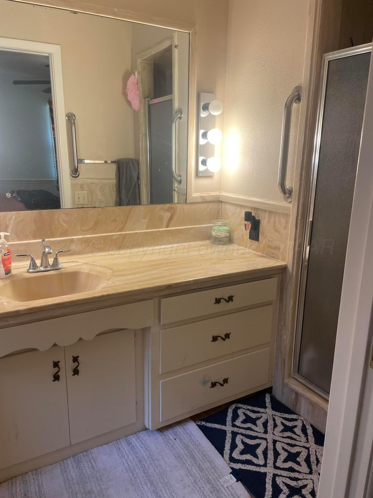 6200 Hanson Road Amarillo, TX 79106 - Photo 10 of 22 a bathroom with a sink and a mirror