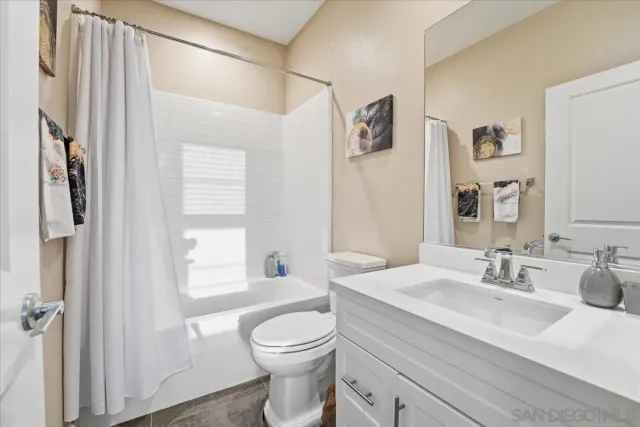 a bed sitting in a spacious bedroom next to a window and a mirror