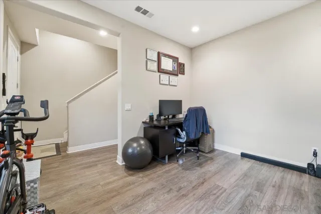 a kitchen with stainless steel appliances granite countertop a stove a sink and white cabinets with wooden floor