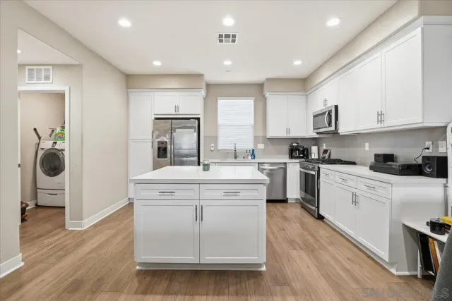 a kitchen with stainless steel appliances granite countertop a sink stove top oven and cabinets