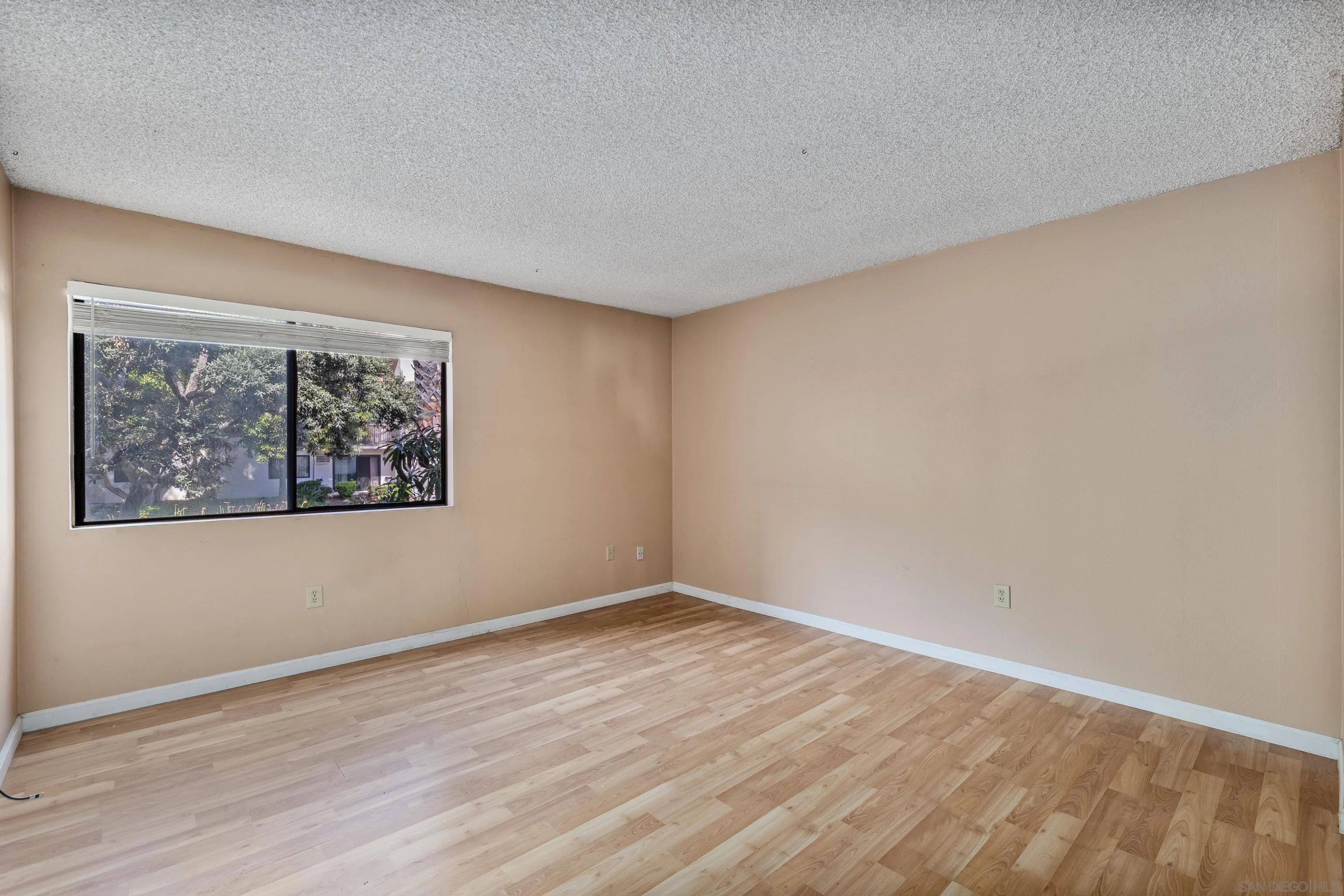 6780 Friars Road, Unit 212 San Diego, CA 92108 - Photo 11 of 25 a view of an empty room with wooden floor and window