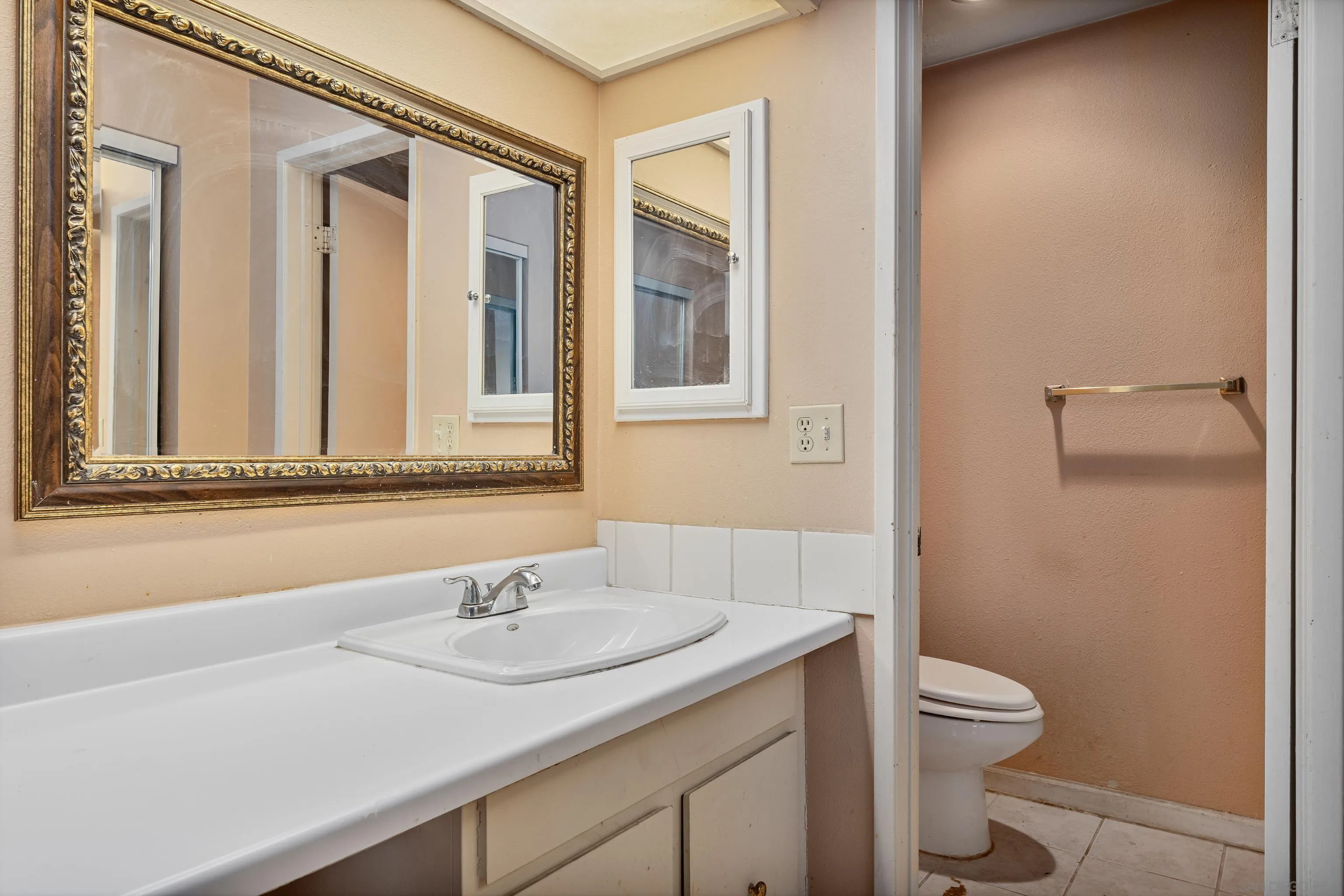 6780 Friars Road, Unit 212 San Diego, CA 92108 - Photo 15 of 25 a bathroom with a granite countertop sink a toilet and a mirror
