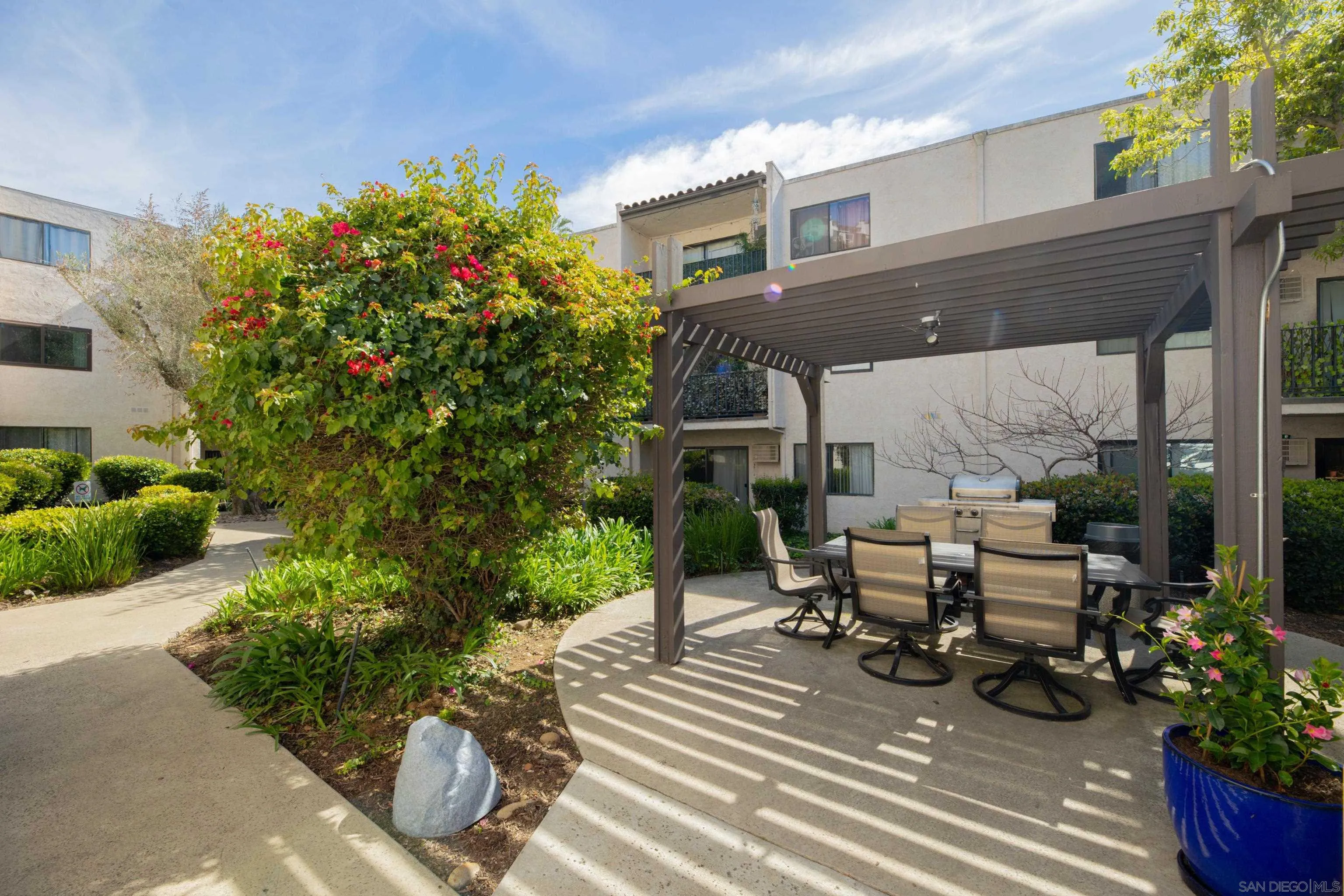 6780 Friars Road, Unit 212 San Diego, CA 92108 - Photo 20 of 25 a view of a patio with table and chairs potted plants and floor to ceiling window