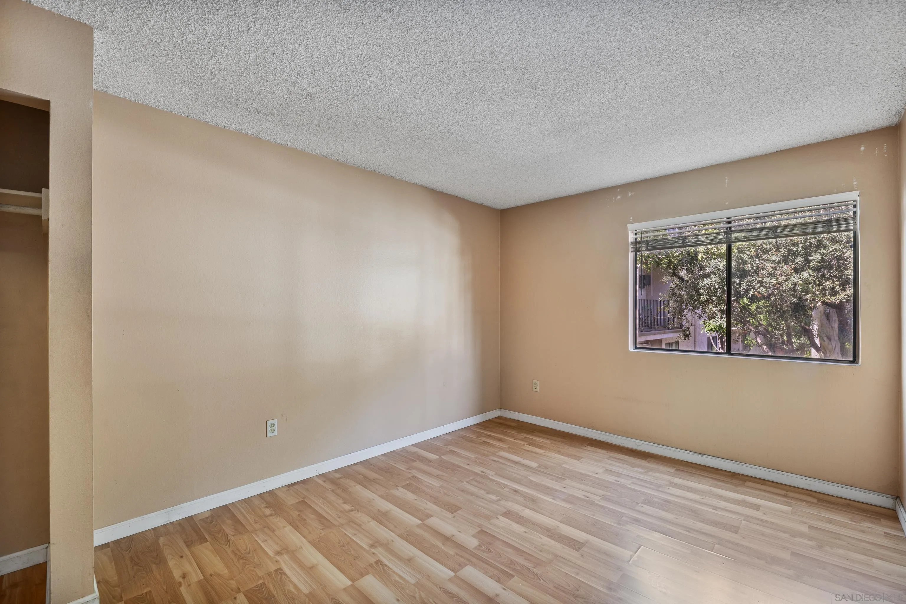 6780 Friars Road, Unit 212 San Diego, CA 92108 - Photo 9 of 25 a view of an empty room with window and wooden floor