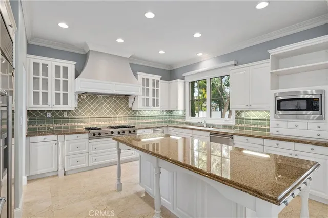 a kitchen with stainless steel appliances granite countertop a sink stove and cabinets