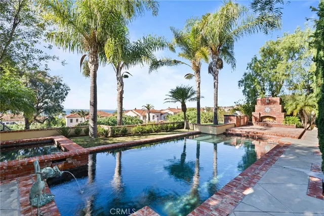 a swimming pool with outdoor seating and a garden