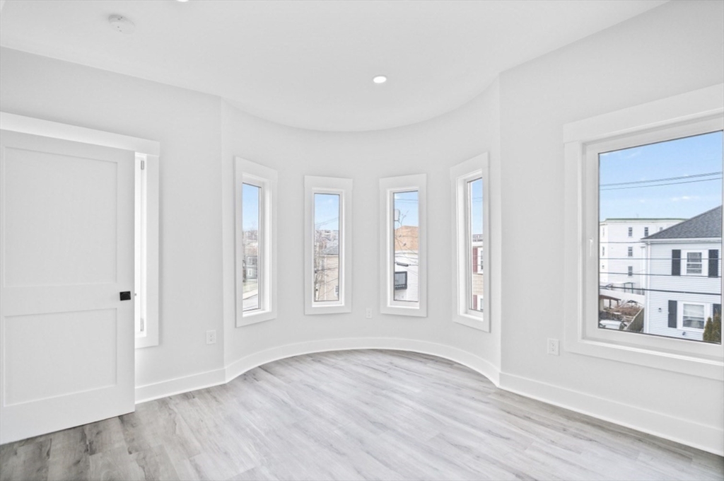 6 Garfield Avenue, Unit 1 Revere, MA 02151 - Photo 7 of 9 an empty room with wooden floor and windows