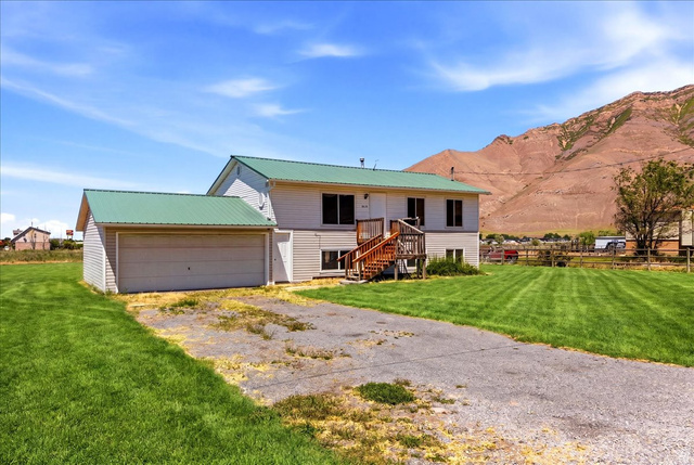 1613 Sunset Road Lake Point, UT 84074 - Photo 2 of 33 Split-level residence featuring a green metal roof and light-colored siding